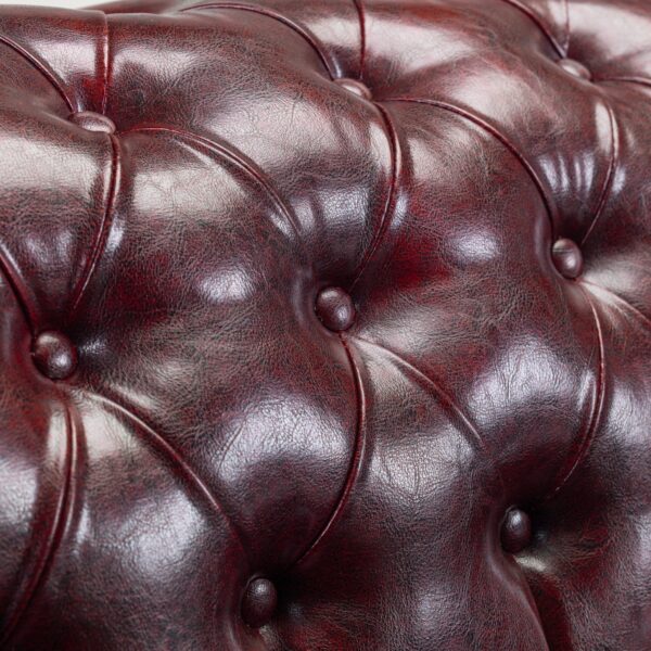 Side angle of Chesterfield sofa showing deep-button tufted back and luxurious oxblood leather.